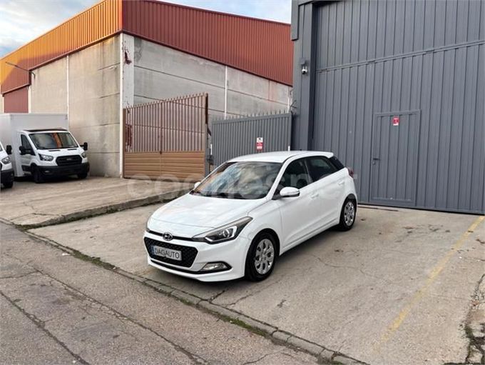 Furgoneta de reparto blanca de 3 plazas y 80.000 km estacionada sobre hormigón. Otra furgoneta al fondo.