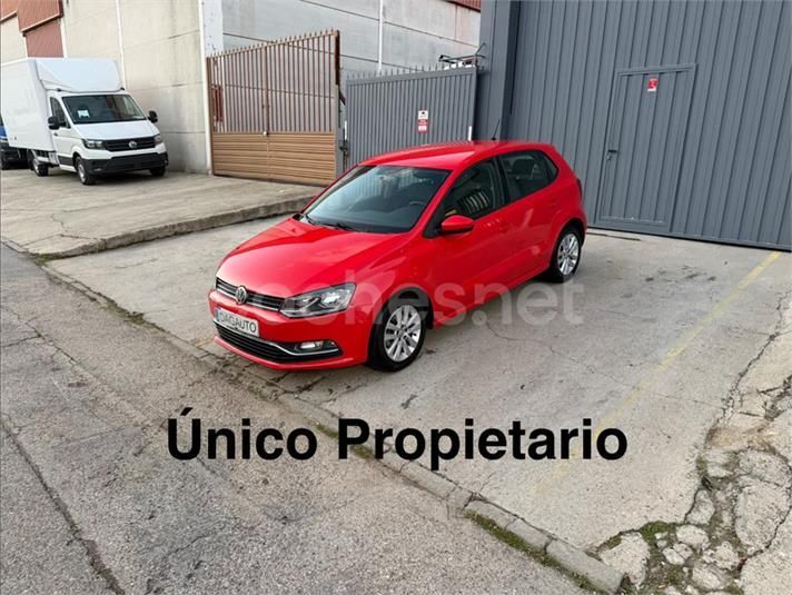 Furgoneta blanca estacionada frente a un garaje gris con un cartel de