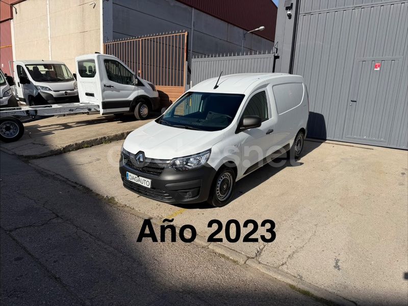 Furgoneta Renault de color blanco, año 2023, estacionada en una calle cerca de un edificio, otros vehículos al fondo.