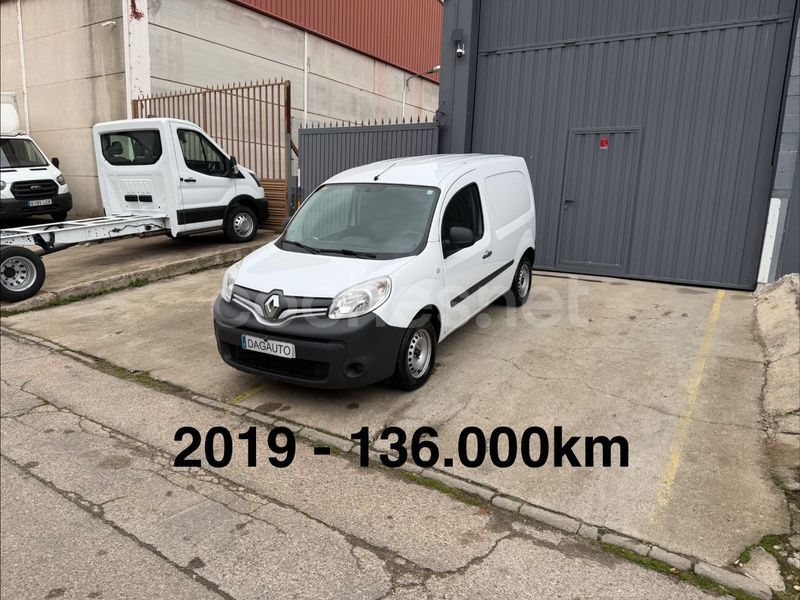 Renault Kangoo blanca estacionada al aire libre, junto a un edificio gris. Se lee