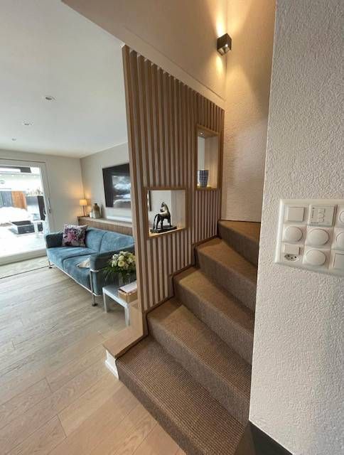 Ein Wohnzimmer mit einer Treppe, die in den zweiten Stock führt. Foto von der Schreinerei Hanselmann GmbH