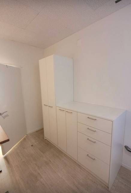 Ein Raum mit weissen Schränken und Schubladen. Foto von der Schreinerei Hanselmann GmbH