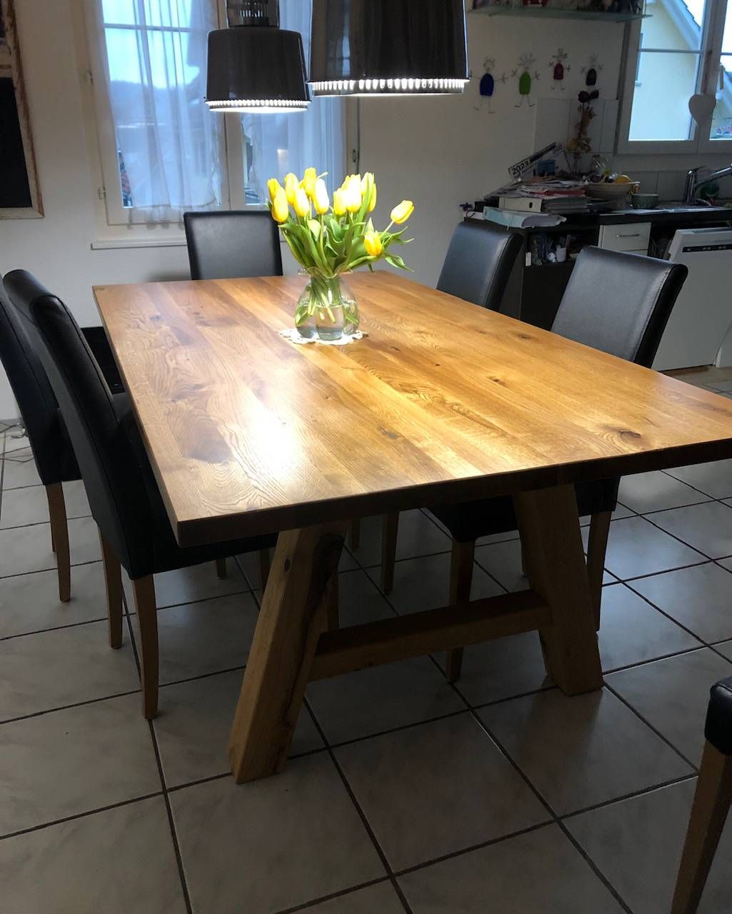 Ein Holztisch mit einer Vase mit Blumen darauf. Foto von der Schreinerei Hanselmann GmbH