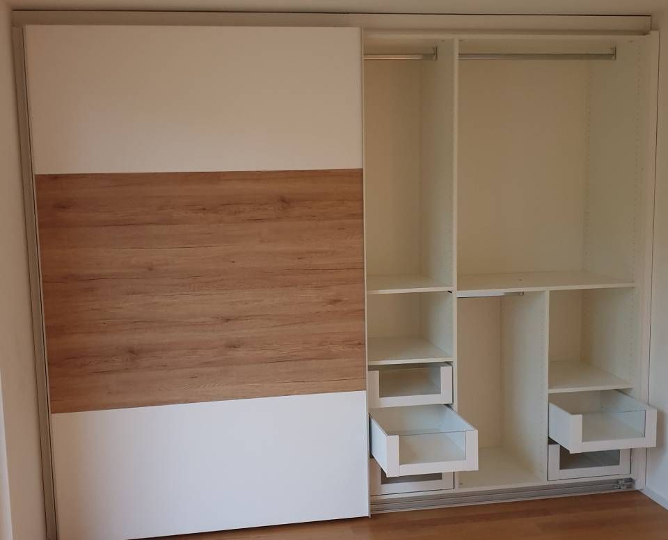 Ein Kleiderschrank mit Schiebetüren und offenen Schubladen. Foto von der Schreinerei Hanselmann GmbH