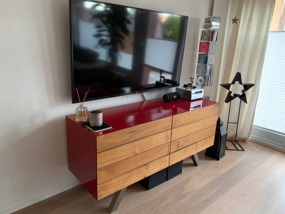 Ein Wohnzimmer mit einer Kommode und einem Flachbildfernseher. Foto von der Schreinerei Hanselmann GmbH