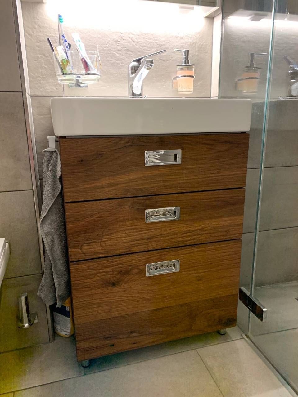 Ein Badezimmerschrank mit drei Schubladen und einem Waschbecken. Foto von der Schreinerei Hanselmann GmbH