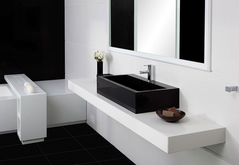 Ein Badezimmer mit einem schwarzen Waschbecken und zwei Spiegeln