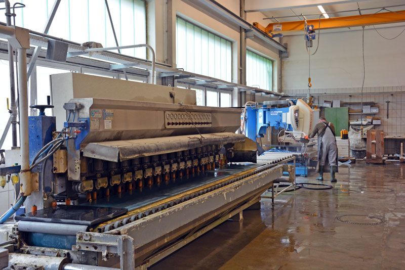 Ein Mann arbeitet in einer Fabrik an einer Maschine.