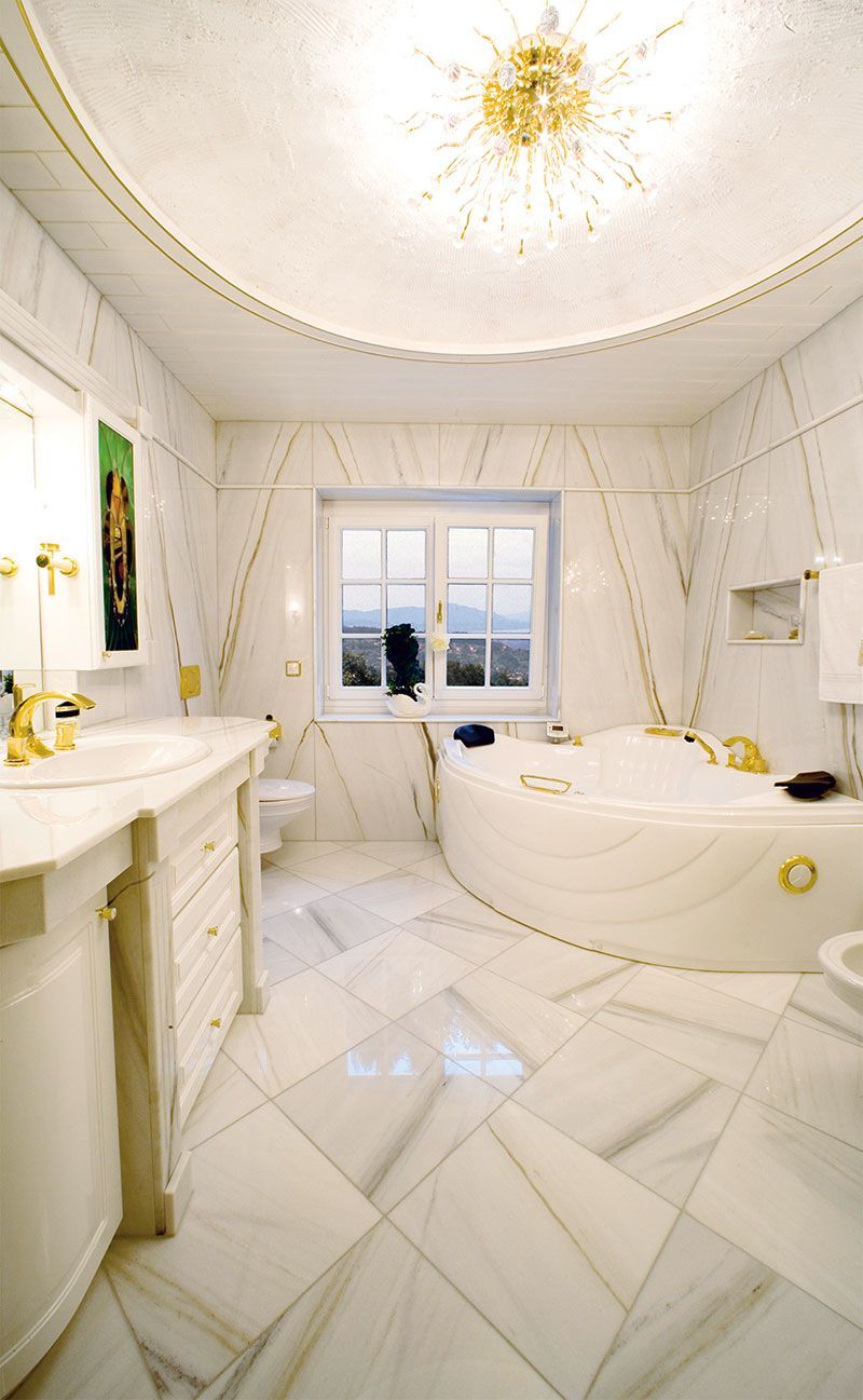 Ein Badezimmer mit Badewanne, Waschbecken, Toilette und Fenster.