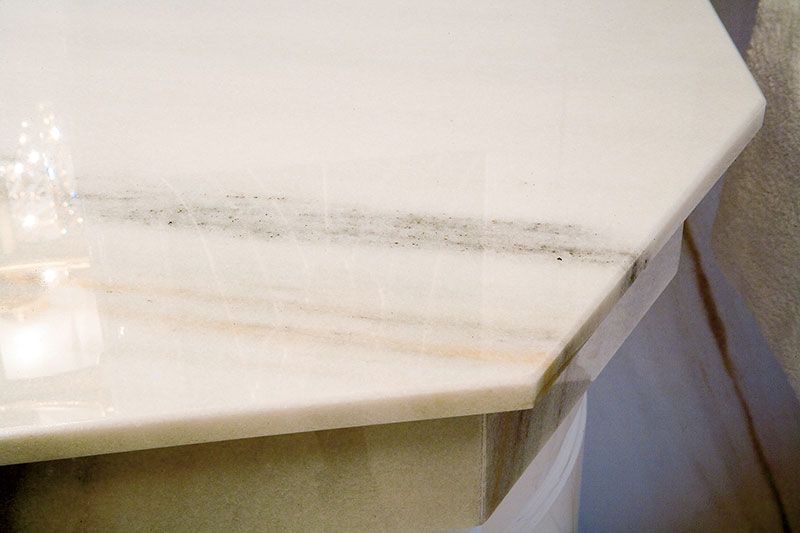 Eine Nahaufnahme einer weißen Marmorarbeitsplatte in einem Badezimmer.