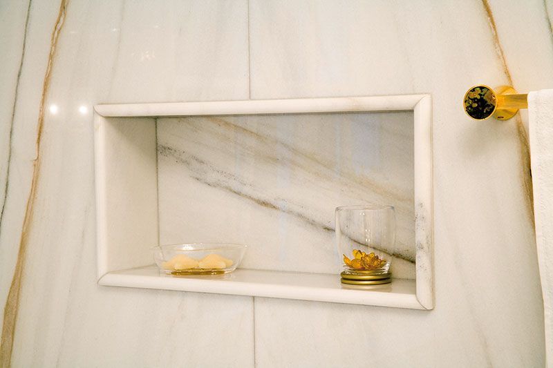 Ein Badezimmer mit einer Seifenschale und einem Glas auf einem Regal.