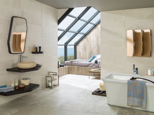 Ein Badezimmer mit Badewanne, Waschbecken, Spiegel und Fenster.