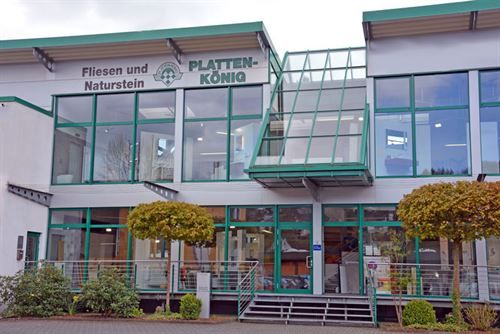 Ein großes Gebäude mit vielen Fenstern und einem Schild mit der Aufschrift „Plattenkönig“