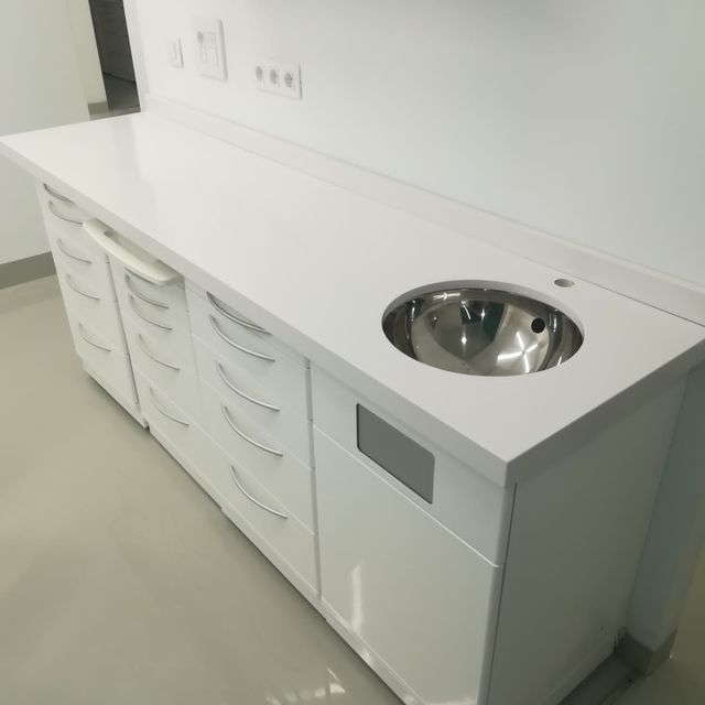 Un armario blanco con un fregadero de acero inoxidable debajo.