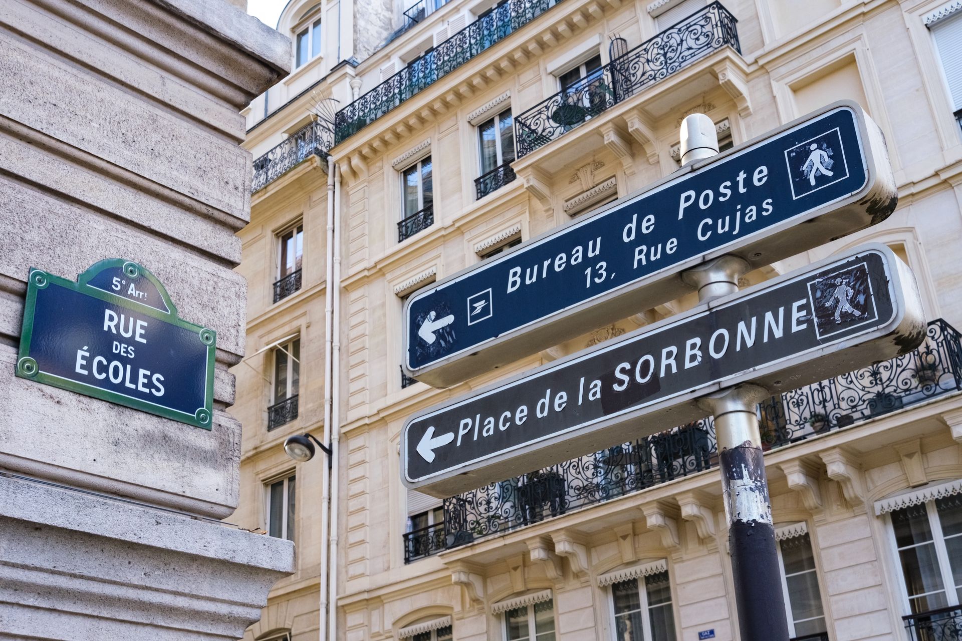 Une plaque de rue et des panneaux de direction