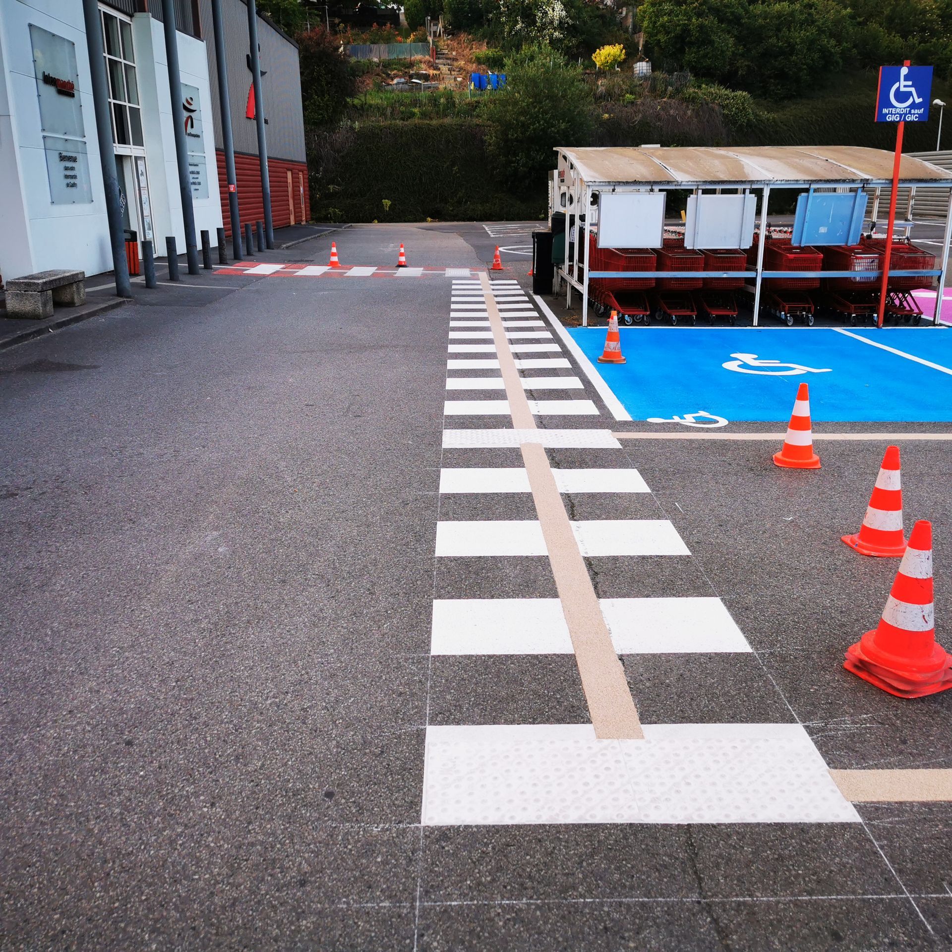 Passage piéton et places de parking PMR de couleur bleue