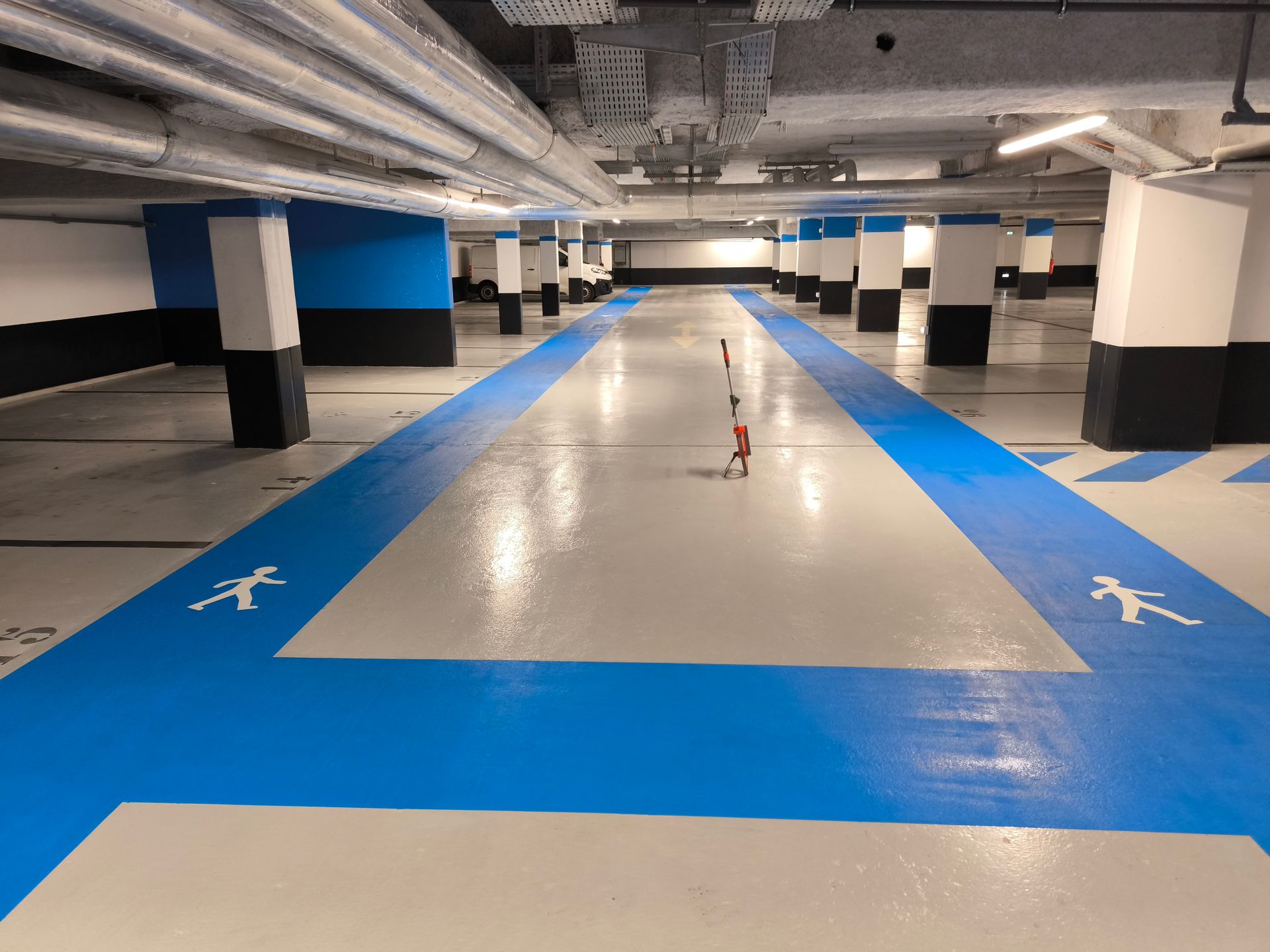 Des marquages au sol de zone piétonne dans un parking souterrain