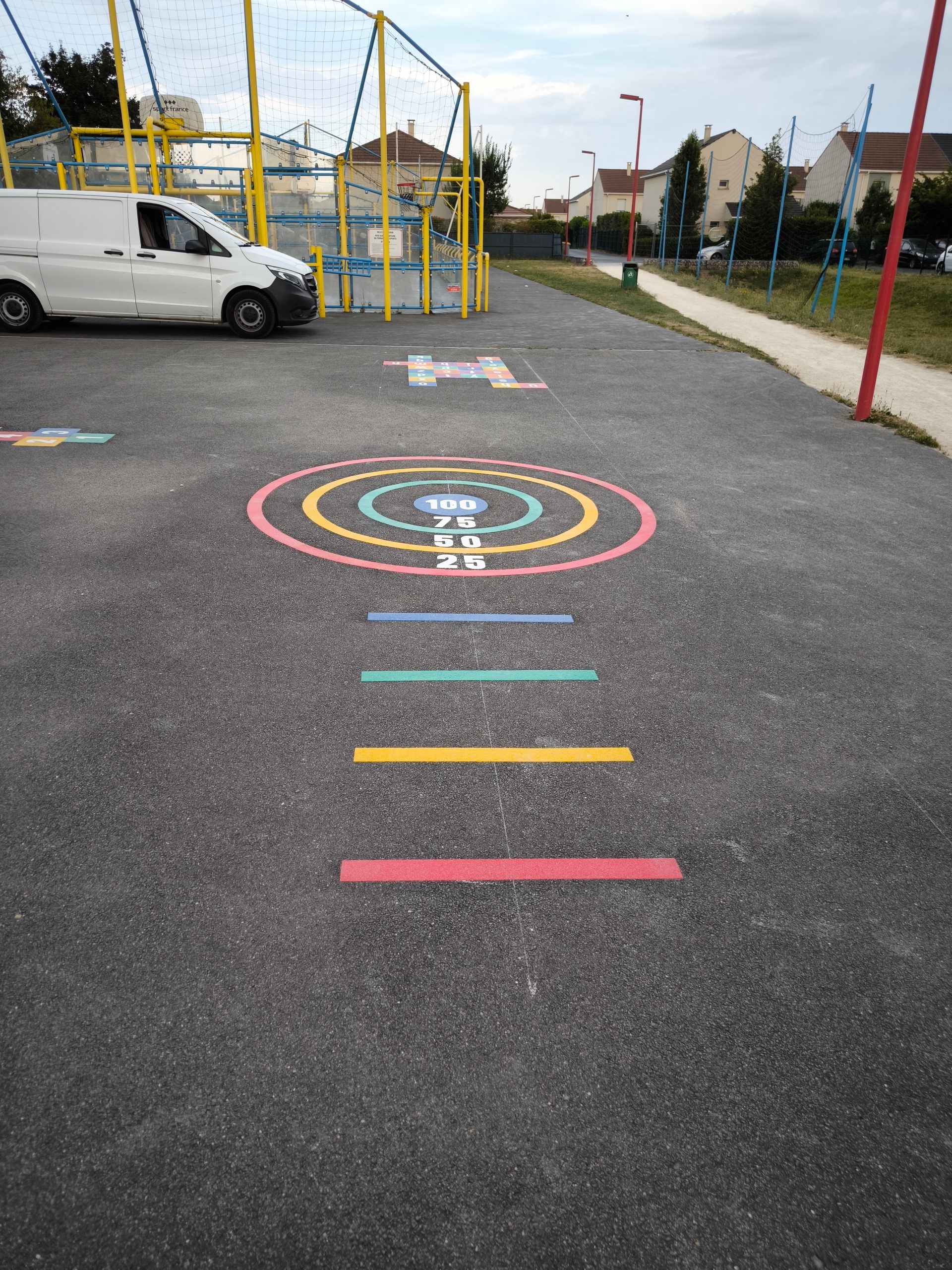 Des enfants jouent à la marelle dans une zone de jeux