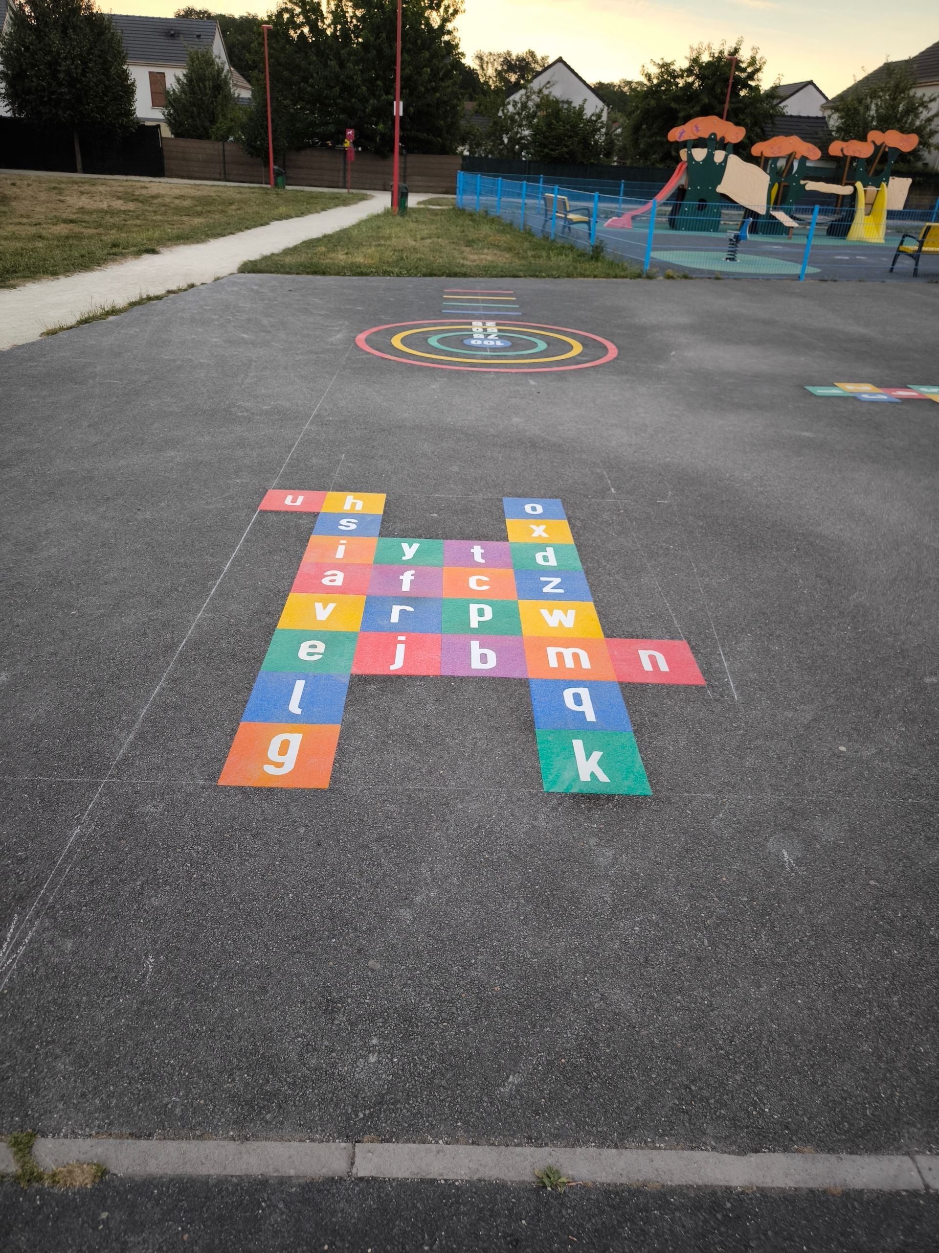 Un jeu coloré avec des lettres sur le sol d'une aire de jeux