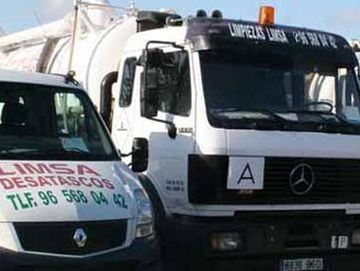 Un camión Mercedes está estacionado al lado de una camioneta blanca.