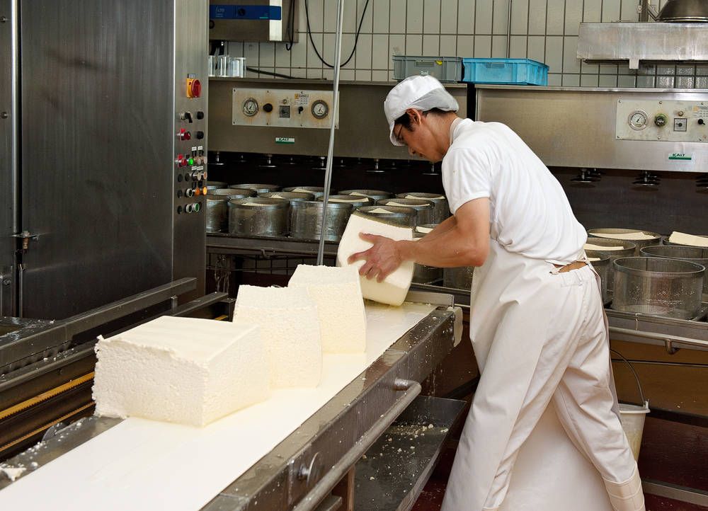 Ein Mann in einer Schürze steht vor einer Theke in einem Restaurant.