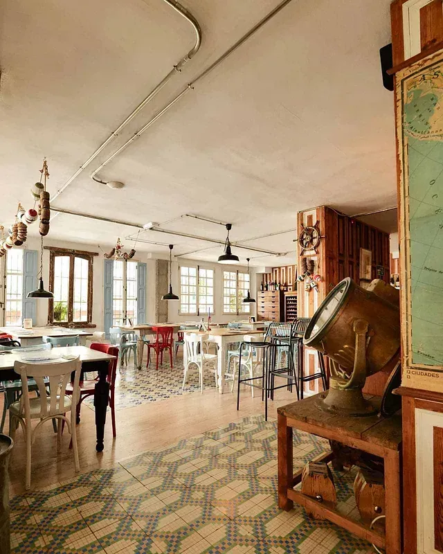 Una gran sala con mesas y sillas y un mapa en la pared.