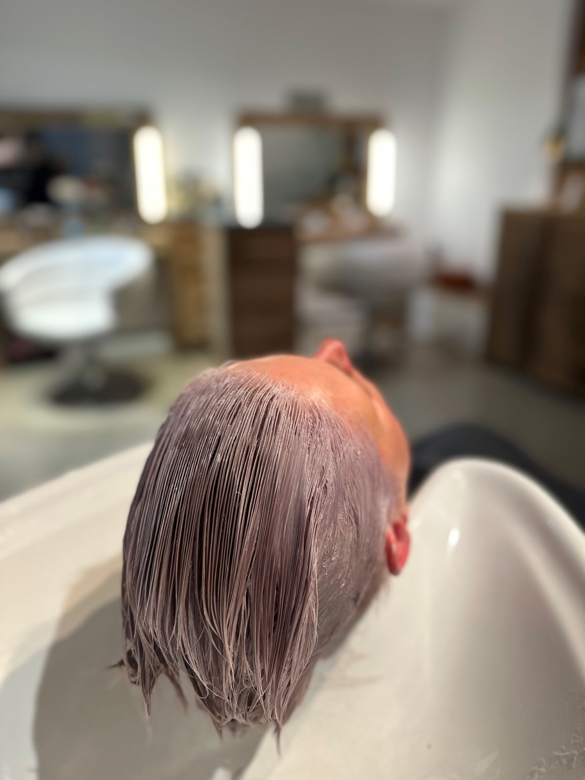 Eine Person wäscht in einem Waschbecken in einem Friseursalon ihre Haare.