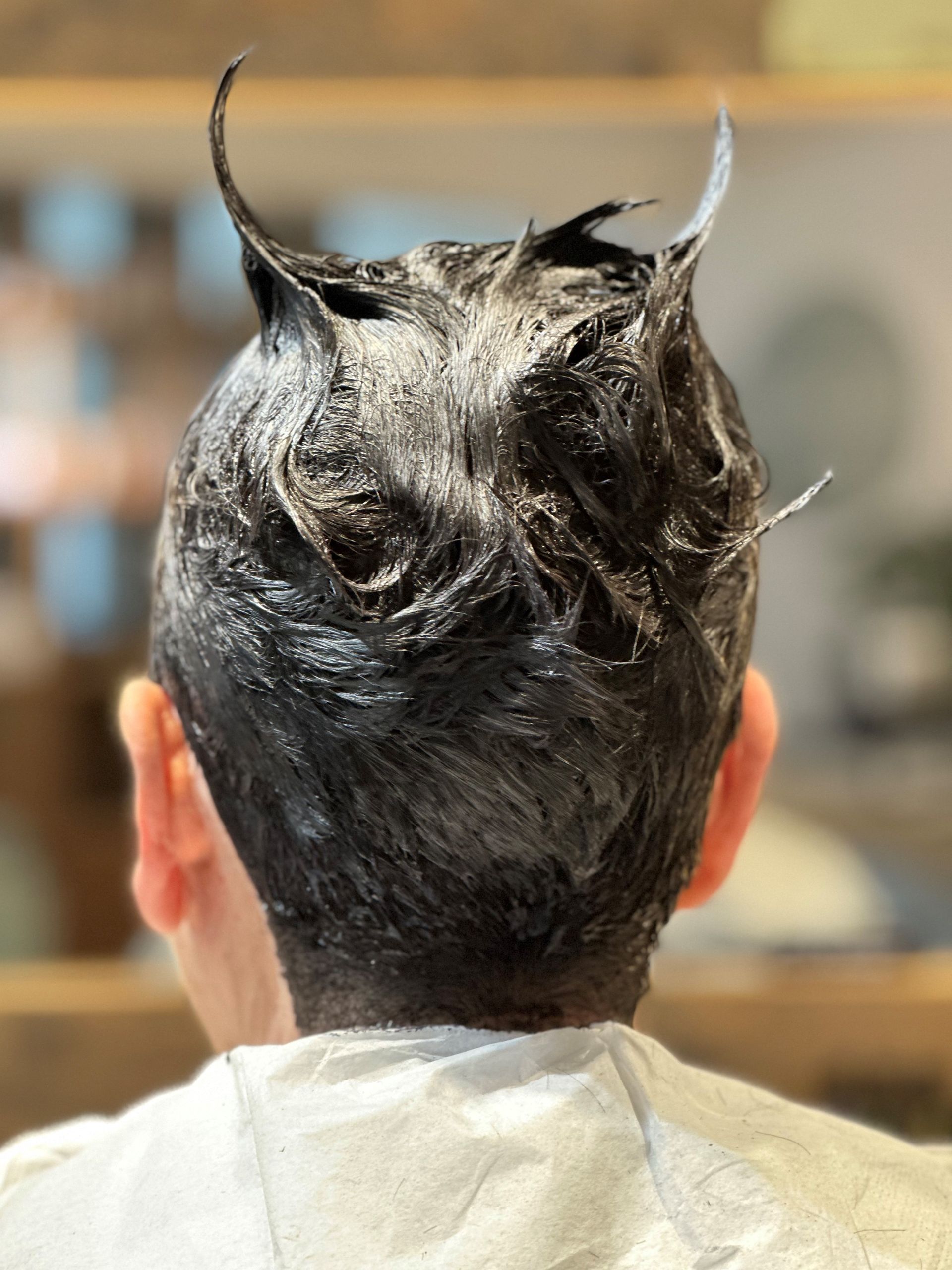 Der Hinterkopf einer Person mit Haarfärbemittel darauf.