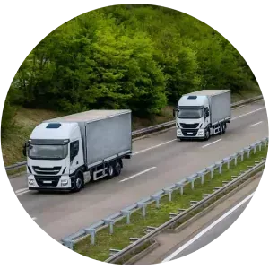 Dos camiones circulan por una autopista uno al lado del otro.