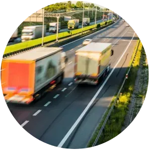 Varios camiones circulan por una autopista en círculo.