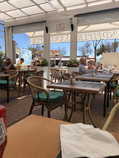 Una botella de ketchup está sobre una mesa en un restaurante.