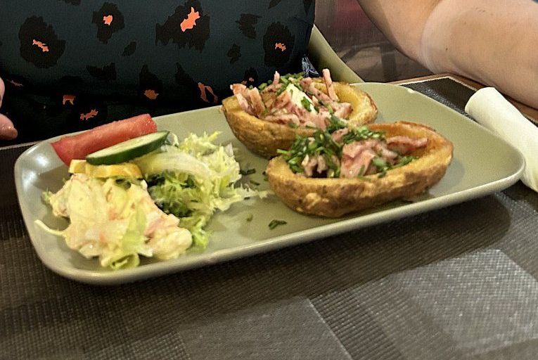 Un plato de comida con patatas y verduras en una mesa.
