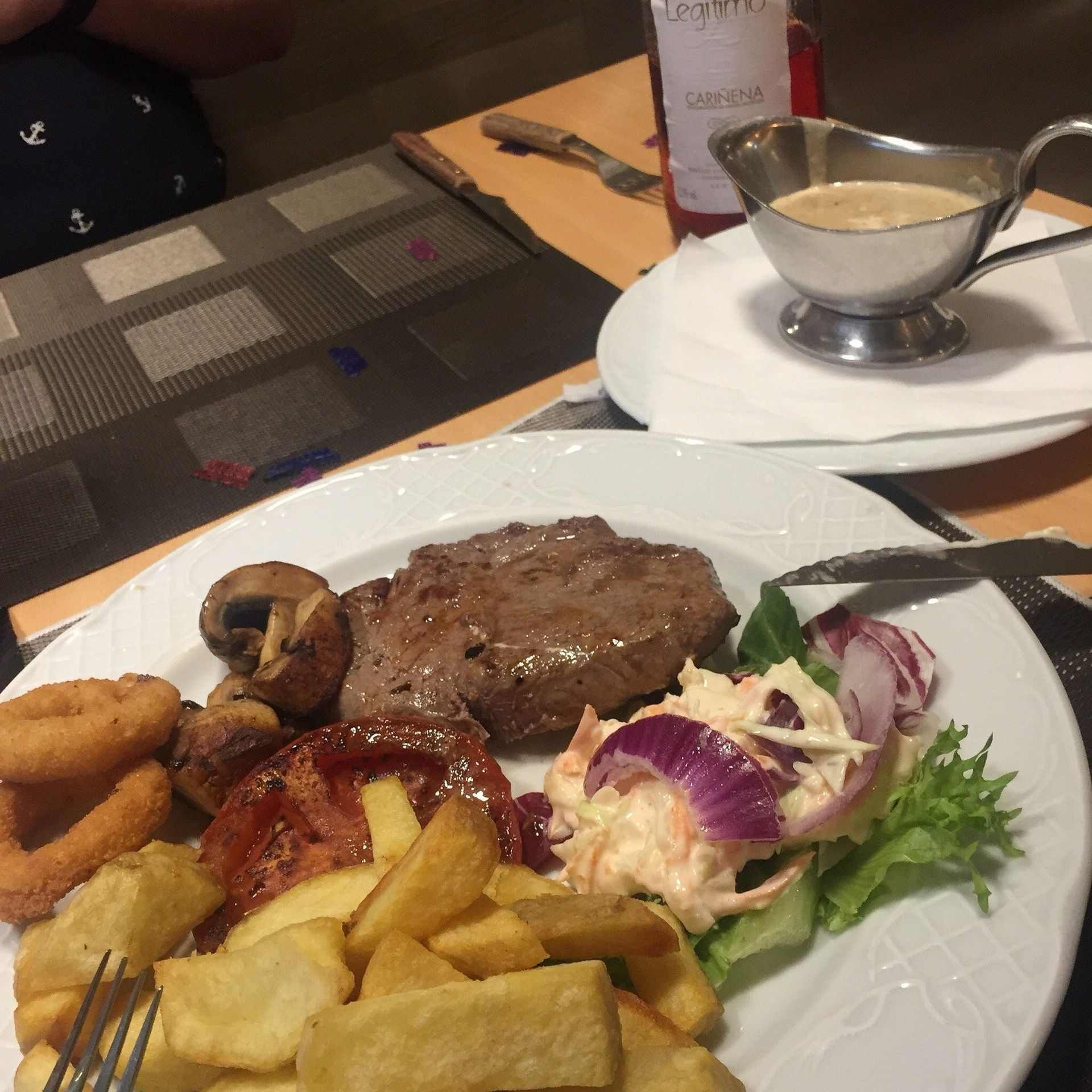 Un plato de comida con una salsera al fondo
