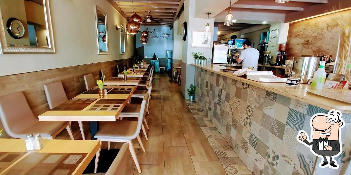 Un restaurante con mesas y sillas y un personaje de dibujos animados en el mostrador.