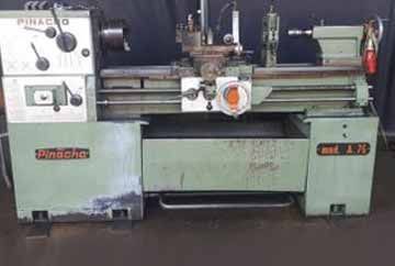 Un torno Pinacho A 70, color verde menta, con diversos pomos y palancas para trabajar metales en un entorno de taller.