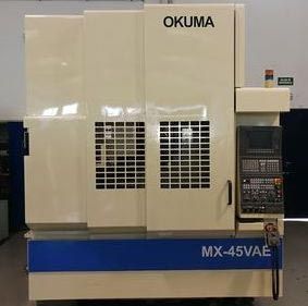 Fresadora CNC Okuma MX-45VAE en taller. Beige y azul con panel de control a la derecha.