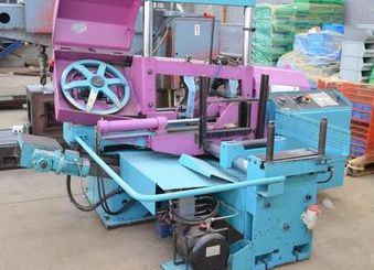 Sierra de cinta industrial de gran tamaño, color azul claro y rosa, para cortar metal.