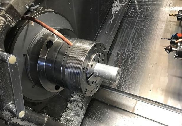 Cilindro de metal que se mecaniza en un torno; herramienta de corte acoplada a la pieza de trabajo, produciendo virutas.