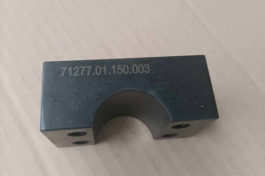 Bloque de metal negro con interior curvado y grabado numerado.