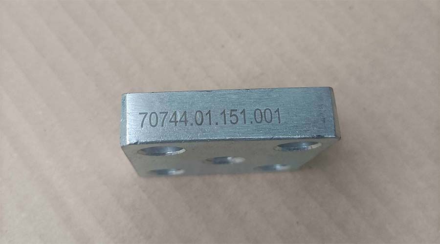 Una pequeña pieza metálica rectangular con el número 70744.01.151.001 grabado en ella, con varios agujeros.