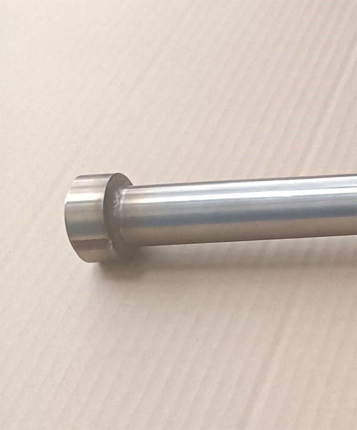 Varilla de metal plateado con un extremo más grande y redondeado.