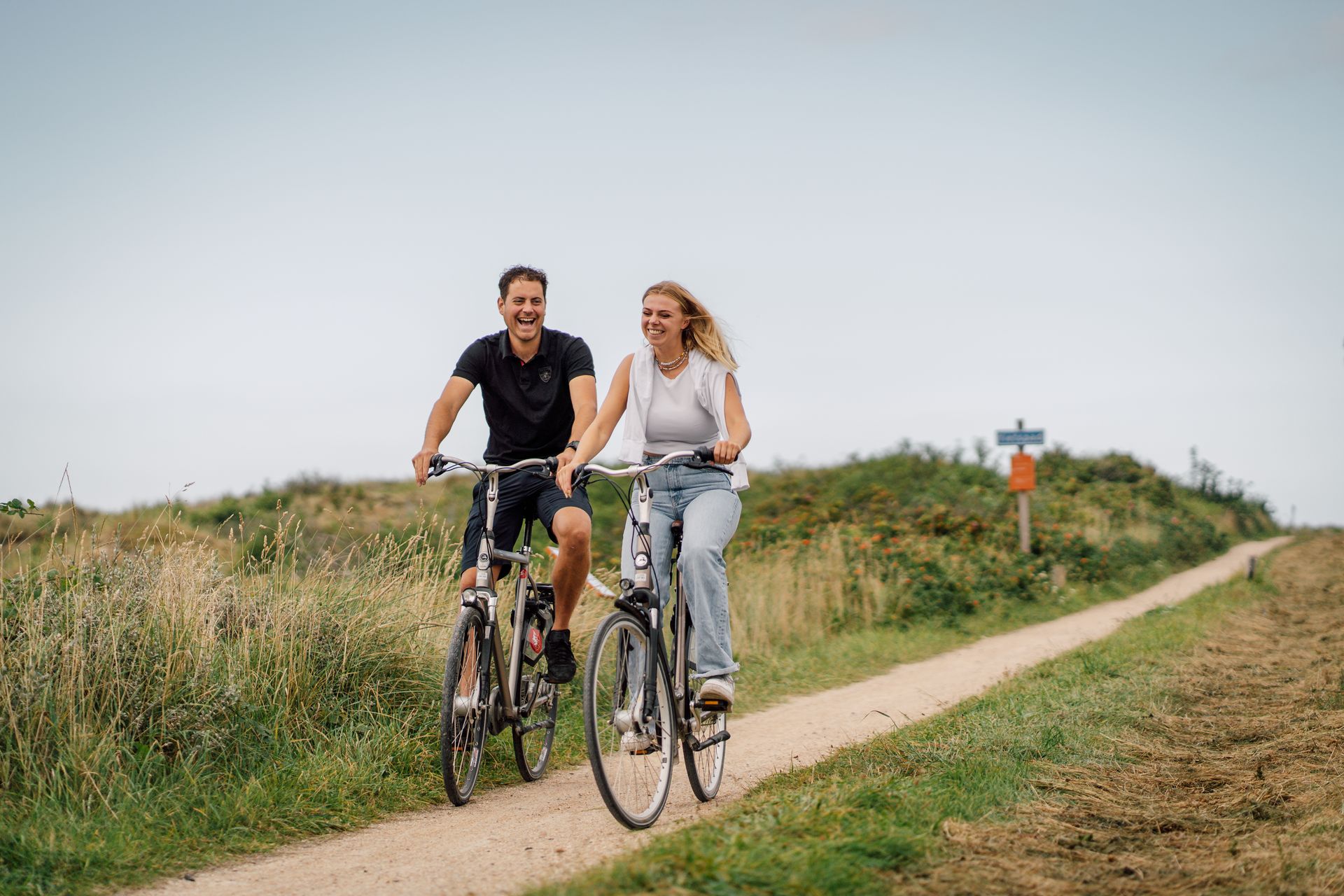 Een stel dat aan het fietsen is op Vlieland in de duinen