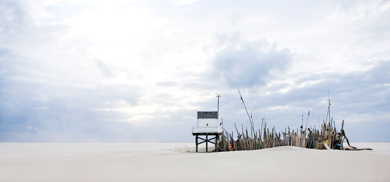 Een reddingspost staat op een zandstrand.