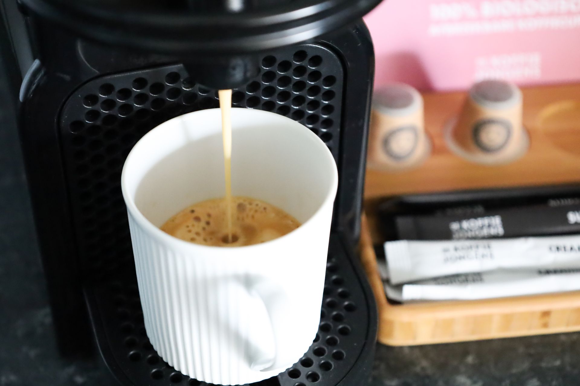 Een kopje koffie wordt in een koffiezetapparaat gegoten