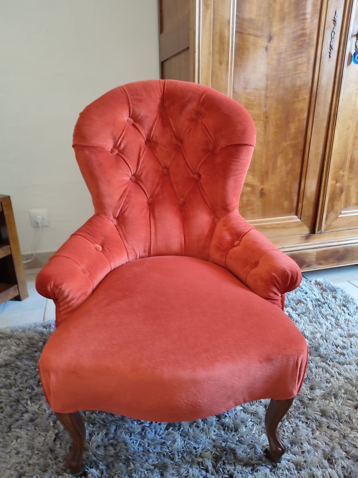 Fauteuil capitonné couleur corail