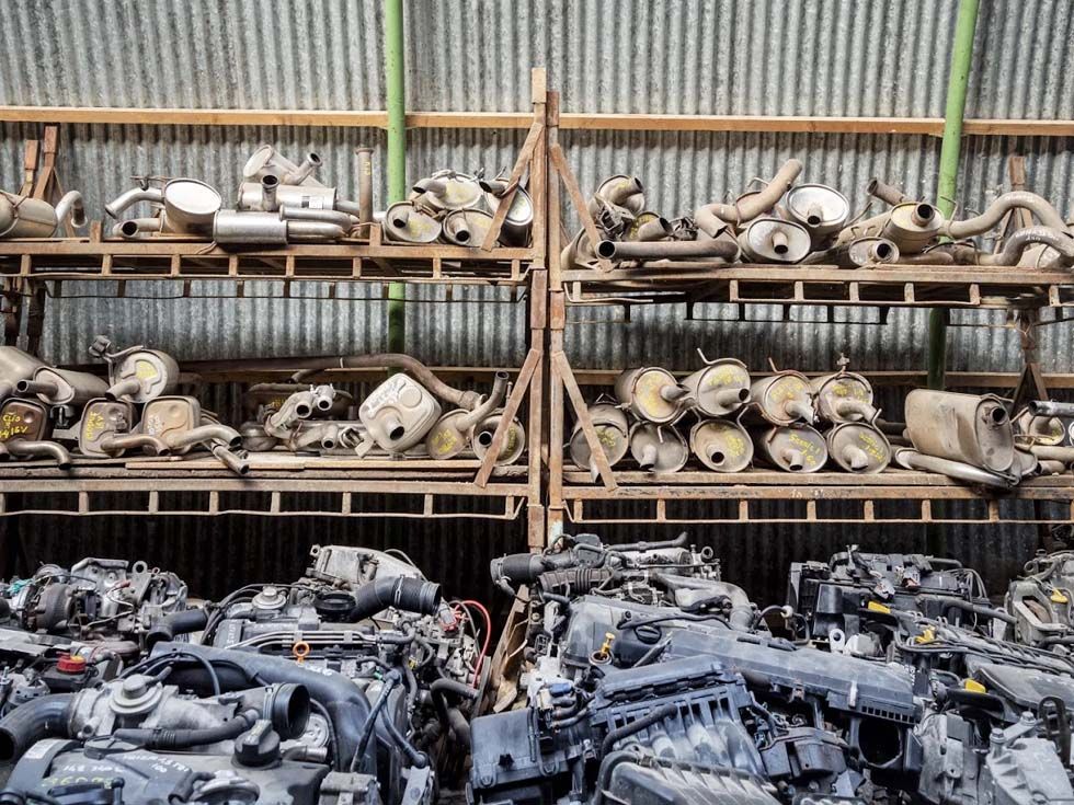 Des étagères remplies de moteurs et de pièces détachées de voitures d'occasion dans un atelier ou une casse automobile