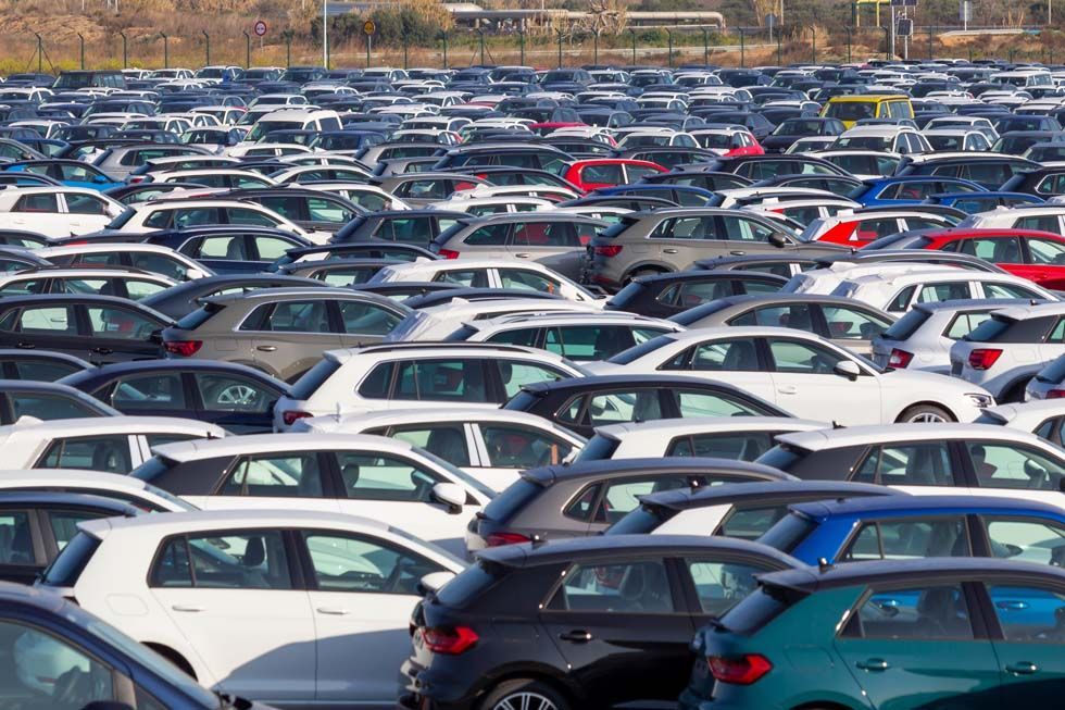 Parking bondé, rempli de rangées de voitures garées de couleurs variées.