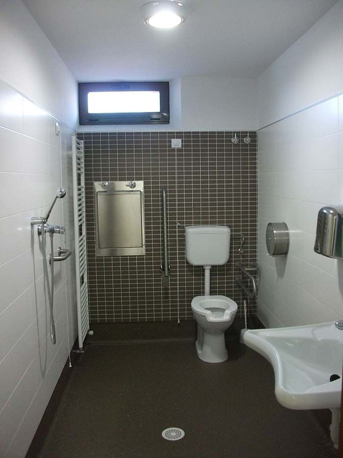 Un baño con inodoro, lavabo y ducha.