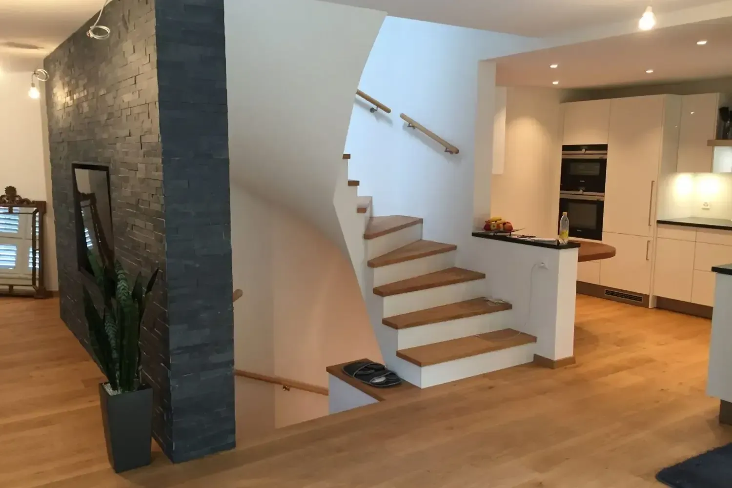 Modernes, offenes Wohnambiente mit freitragender Treppe, Küche und Holzböden