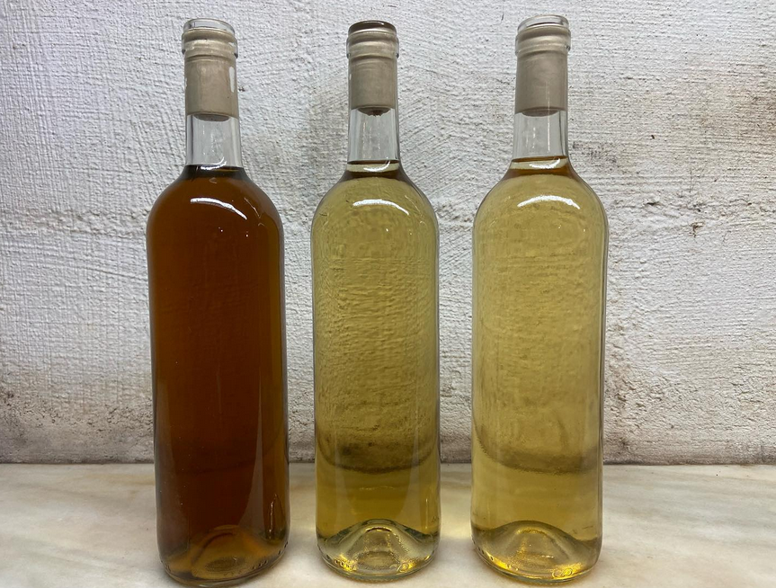 Tres botellas de vino están alineadas una al lado de la otra